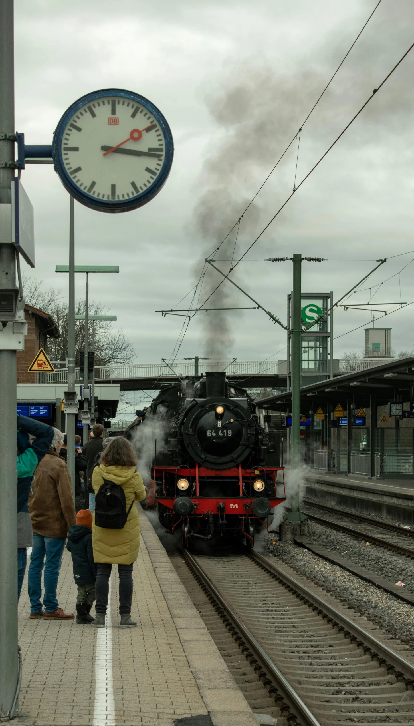 two people standing next to a steam engine