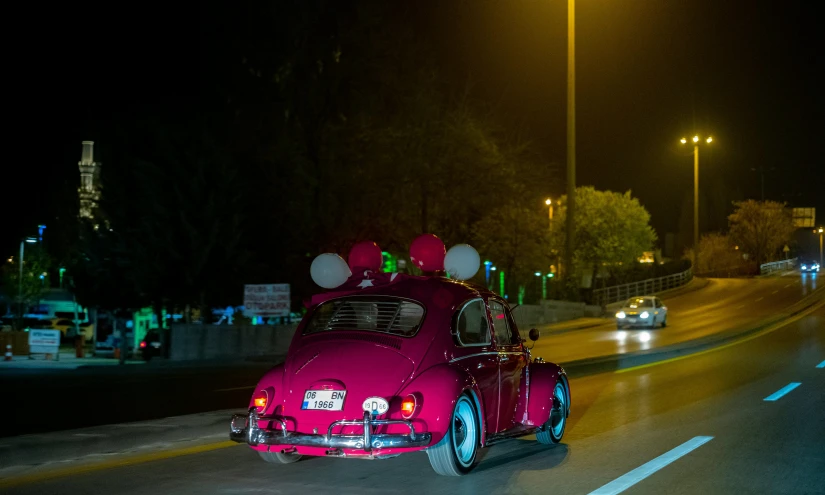 a car with balloons riding down a street