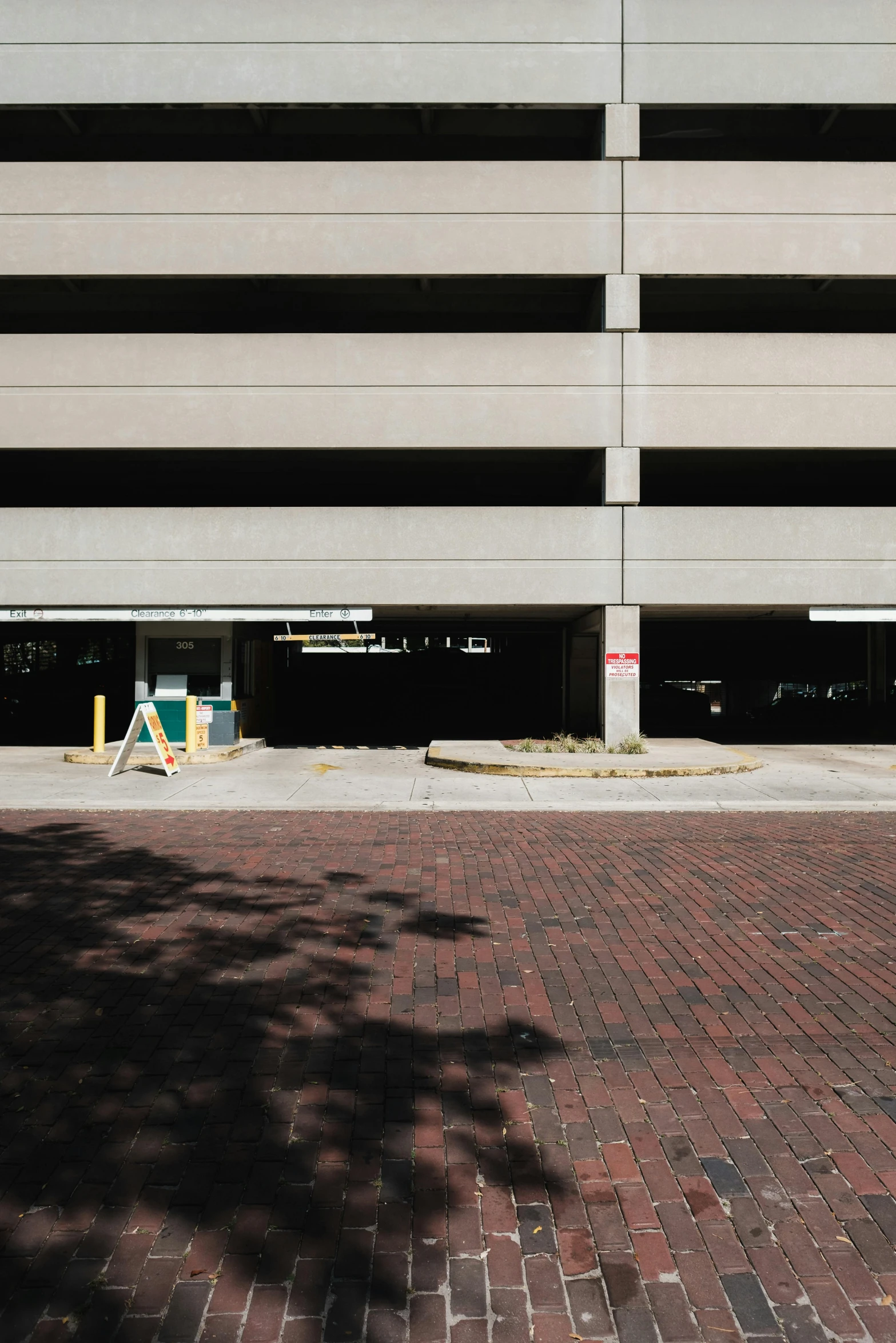 an empty parking garage with a red brick sidewalk and a fire hydrant