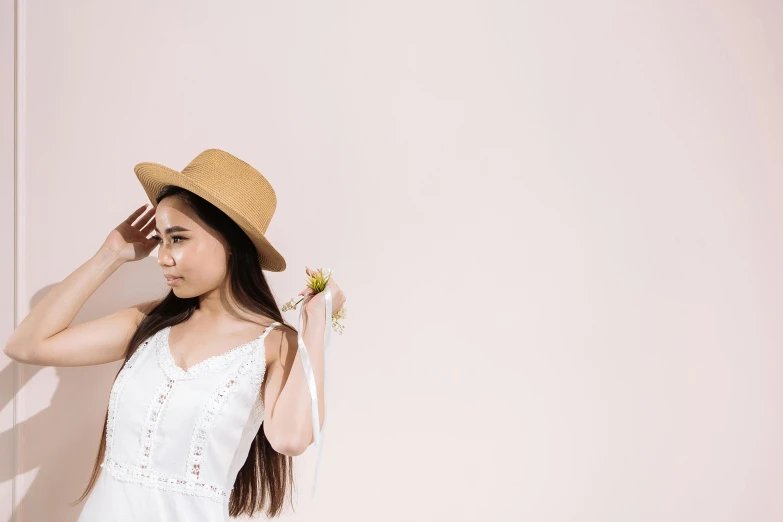 a woman with a straw hat holding flowers