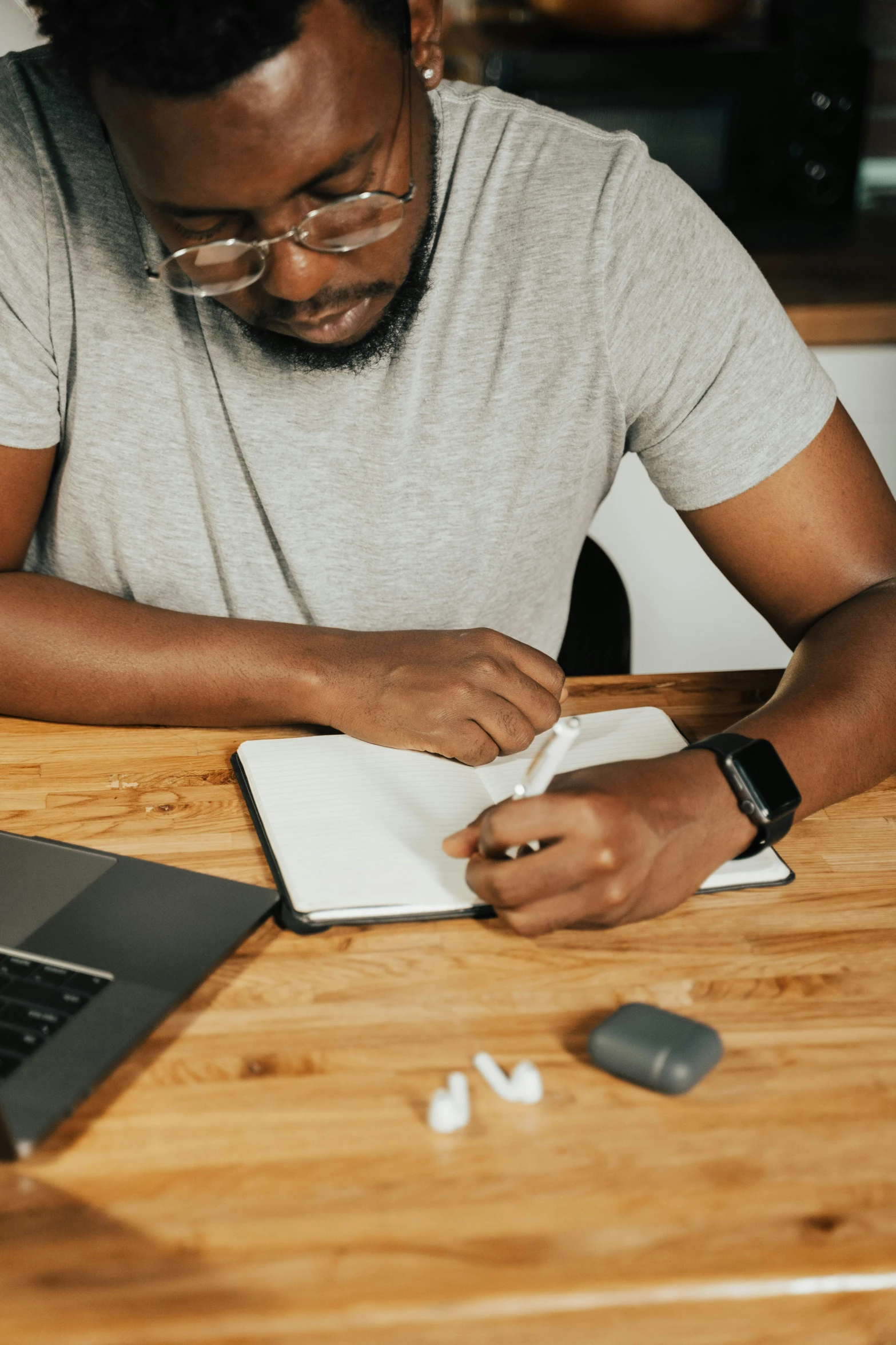 a person sitting at a table with a book and laptop