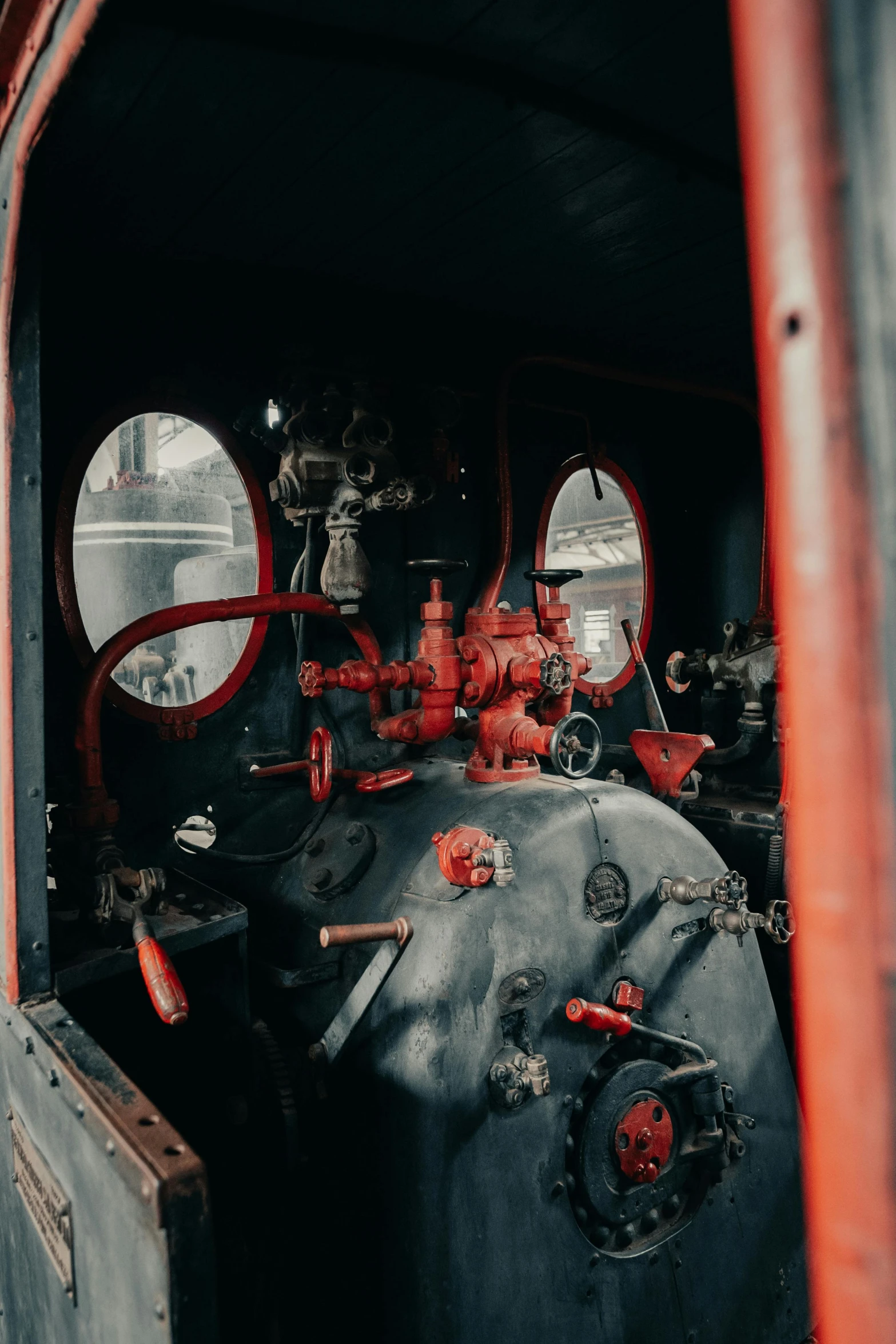 a large black tank with red valves and pipes