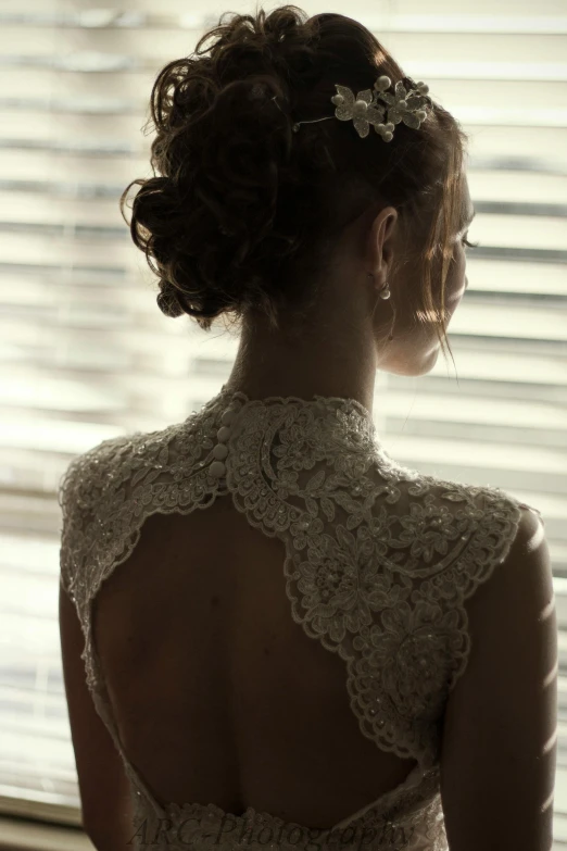 a woman in an elegant dress looks out a window