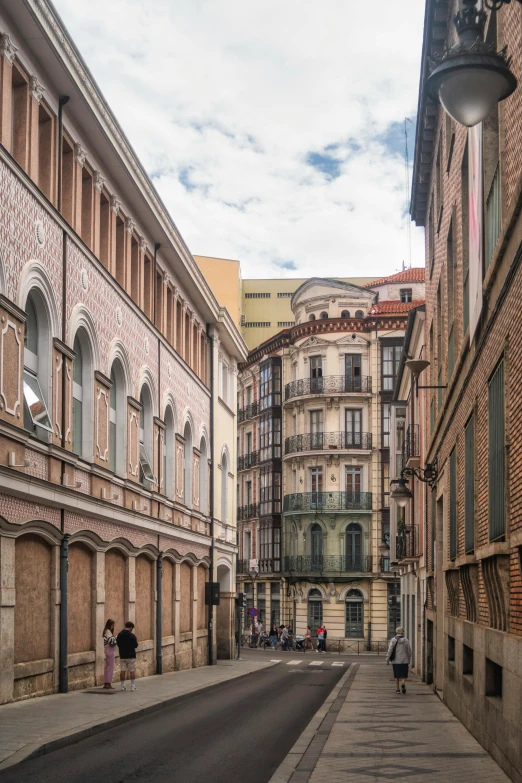 several people walking down an empty street in a large city