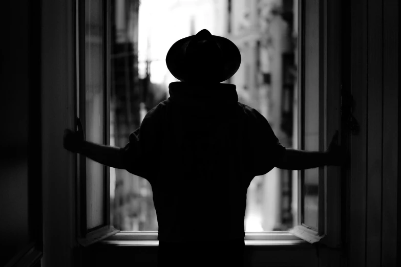 black and white image of a person holding the window up