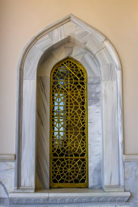 the gold and black glass window is in front of the gray marble wall