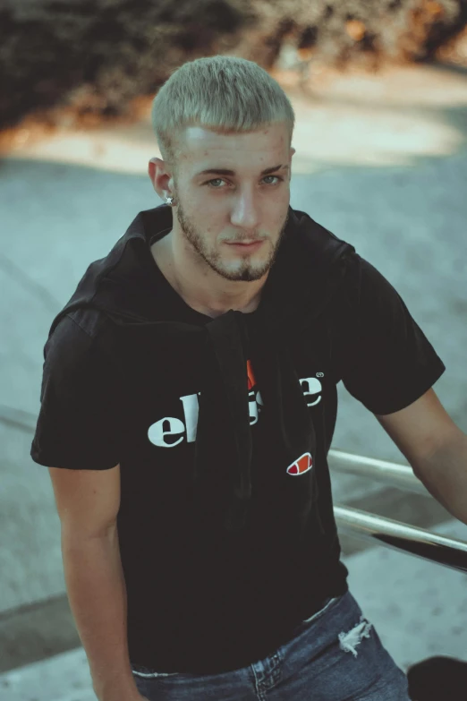 a young man posing on steps with his skateboard