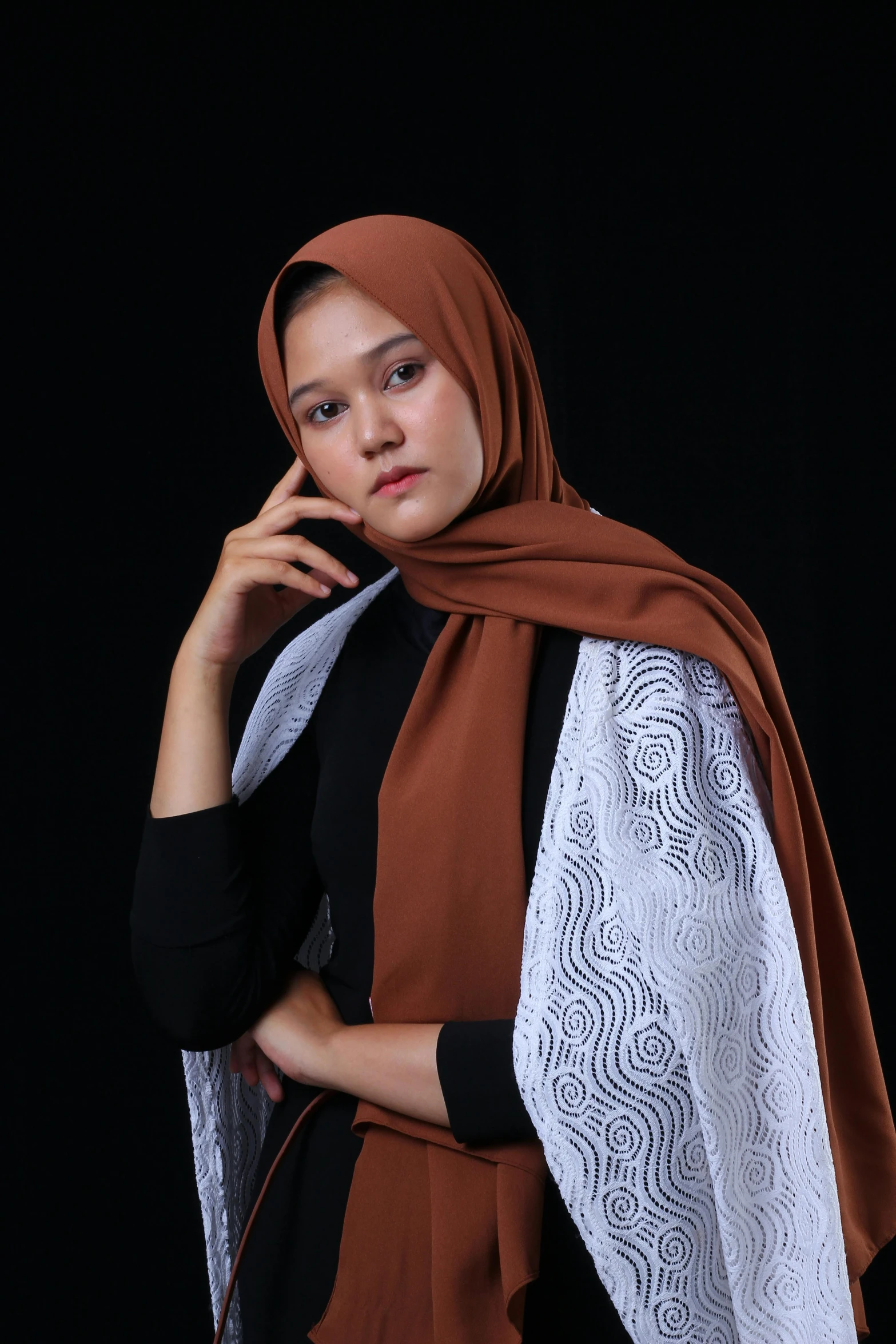 a woman in a dress and shawl standing in a studio