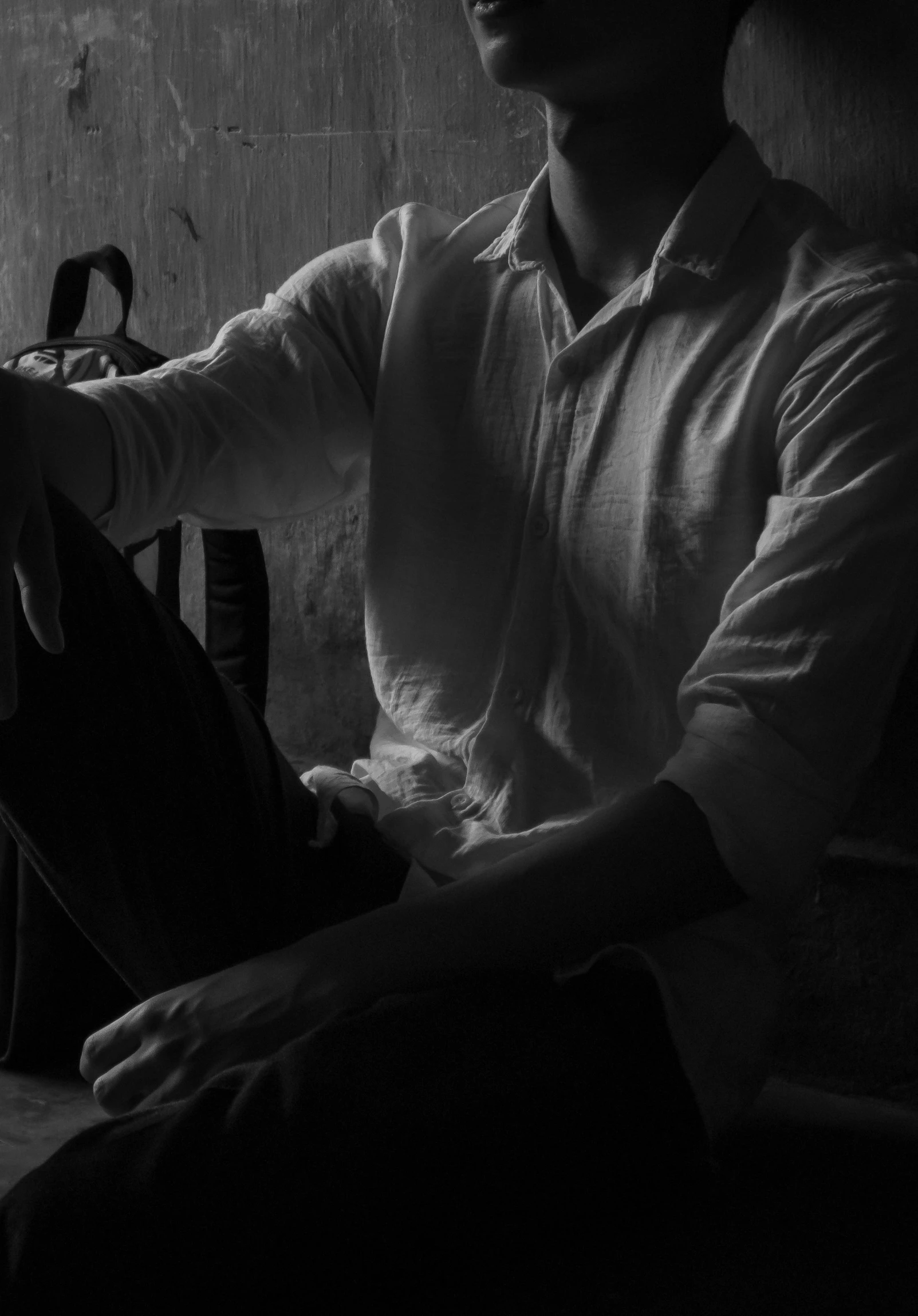 black and white pograph of man in chair, near window