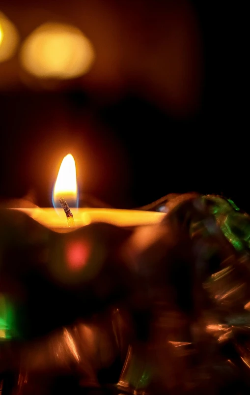 candle is lit up with some blurry lights