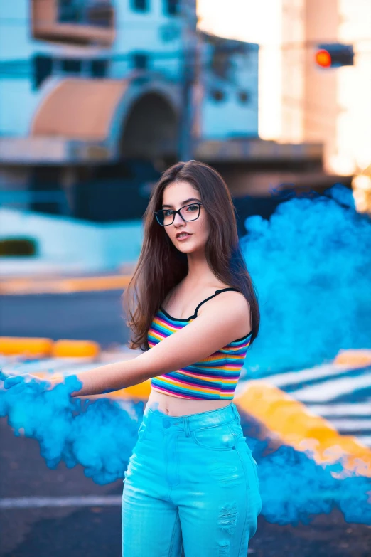 a woman wearing blue pants and striped shirt in front of smoke