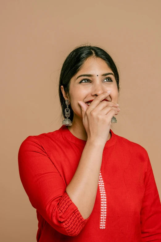 the woman is posing for a picture while covering her mouth