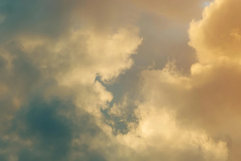 a plane flying across the sky between cloud formations