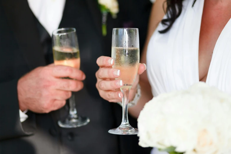 two people holding champagne glasses in their hands