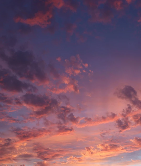 a plane flying in the sky during sunset