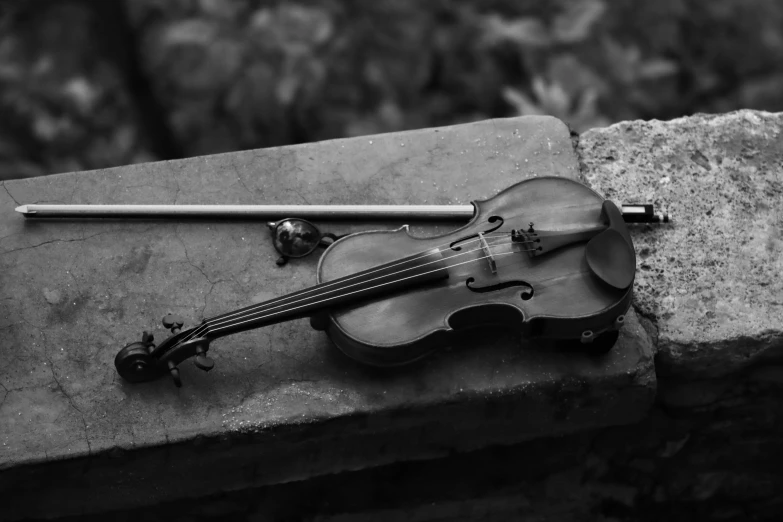 a violin, pipe, and bow rest on the ground