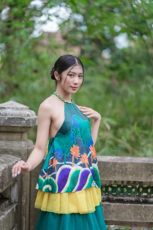 a beautiful young woman wearing a green, yellow and blue frilly skirt