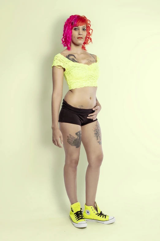 a woman in black shorts and yellow top posing