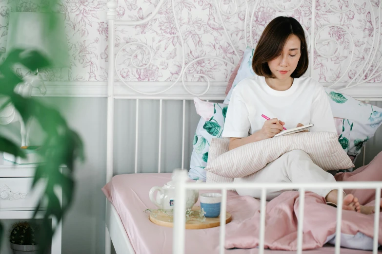 a woman sitting in bed holding a book