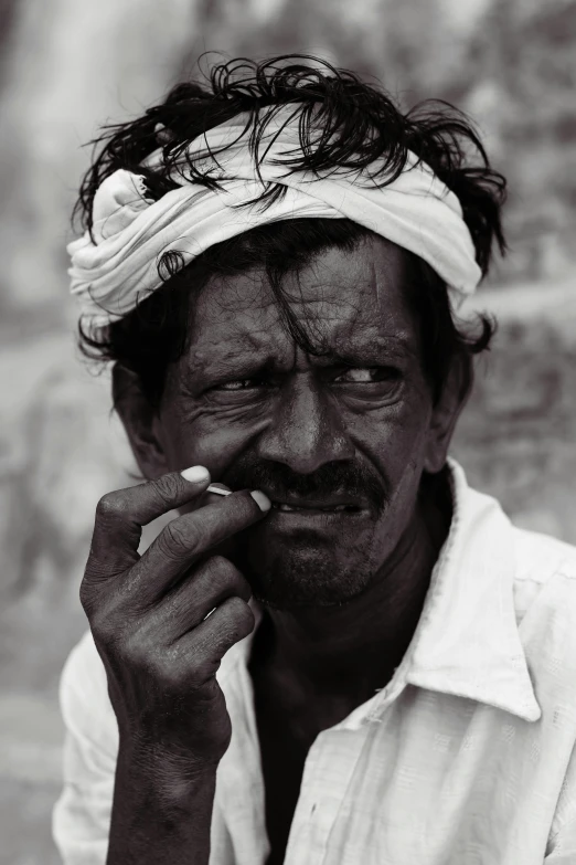 a man in a turban holds a cigarette