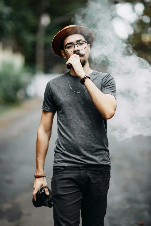 a man wearing glasses, smoking a cigarette