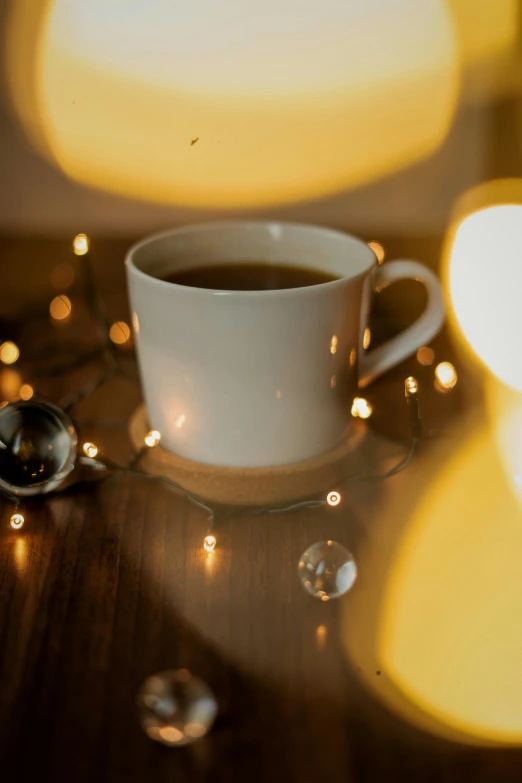 a cup on the table next to some lights