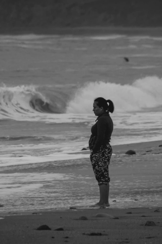 the girl stands alone looking at the water