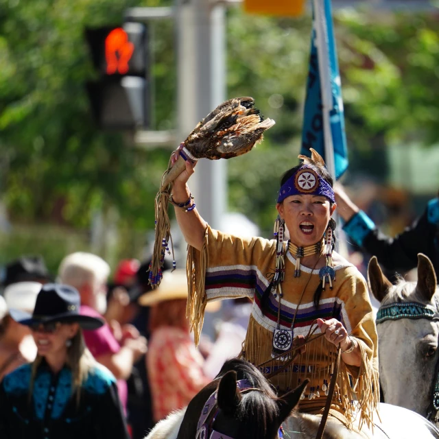 an indian boy on a horse holding a brown animal