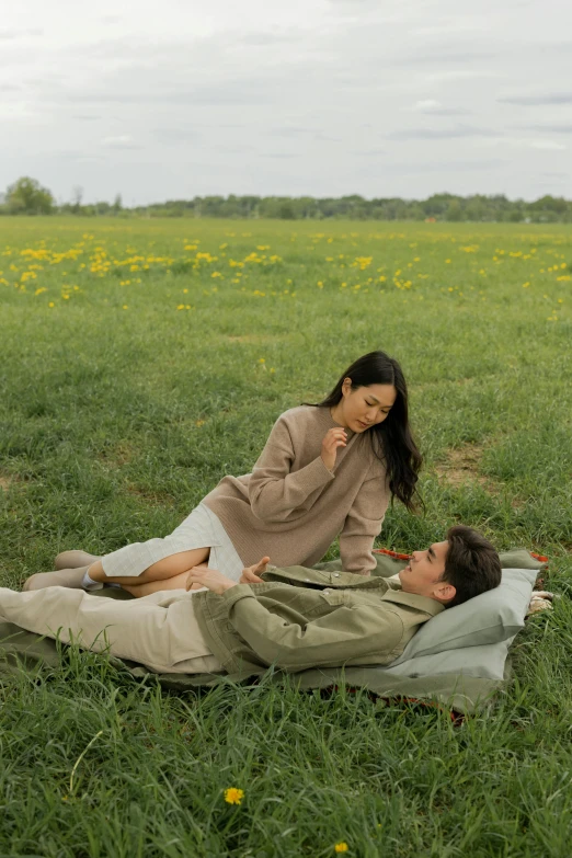 the man is laying in grass with his face on his hand