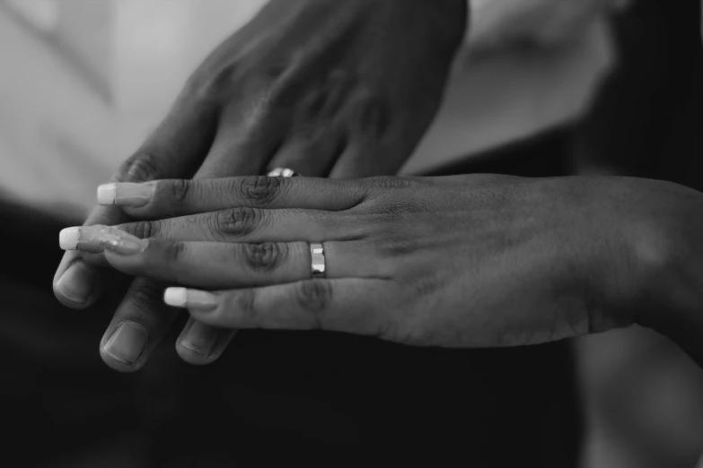 two people holding hands with rings on top of them