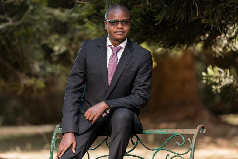 an african american business man sitting on a bench