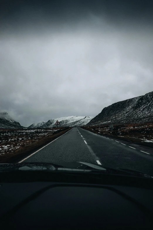 a car driving on the road near mountains