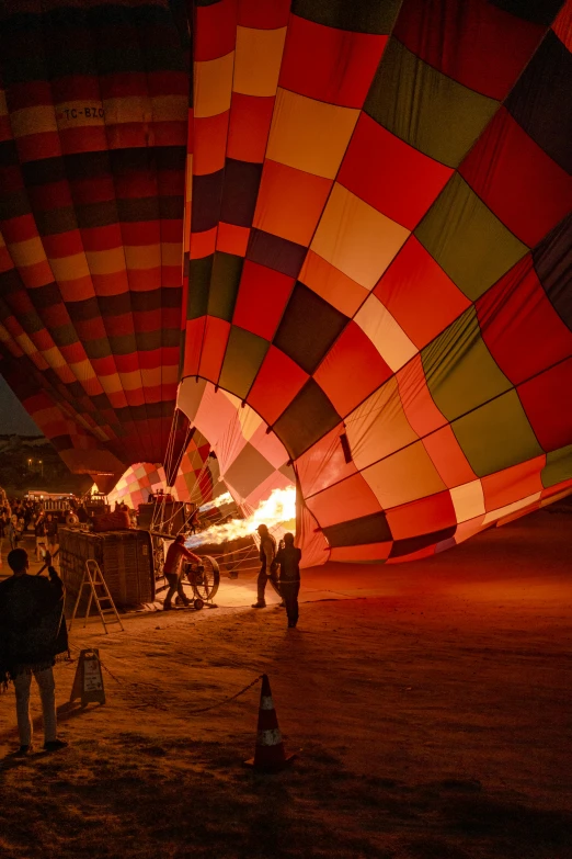 several people observing many colorful  air balloons