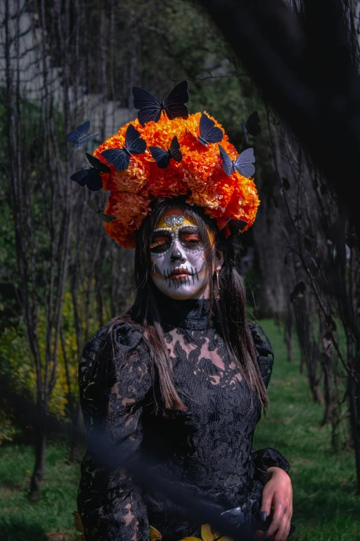 a woman with white makeup, black dress and flowers in her hair