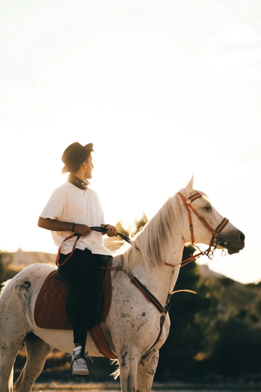 a man is riding a white horse outside