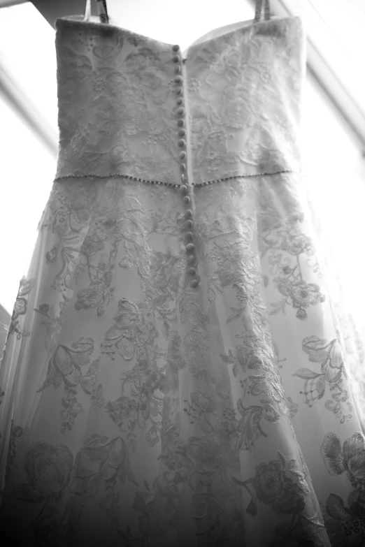 a dress hanging on a rack with curtains
