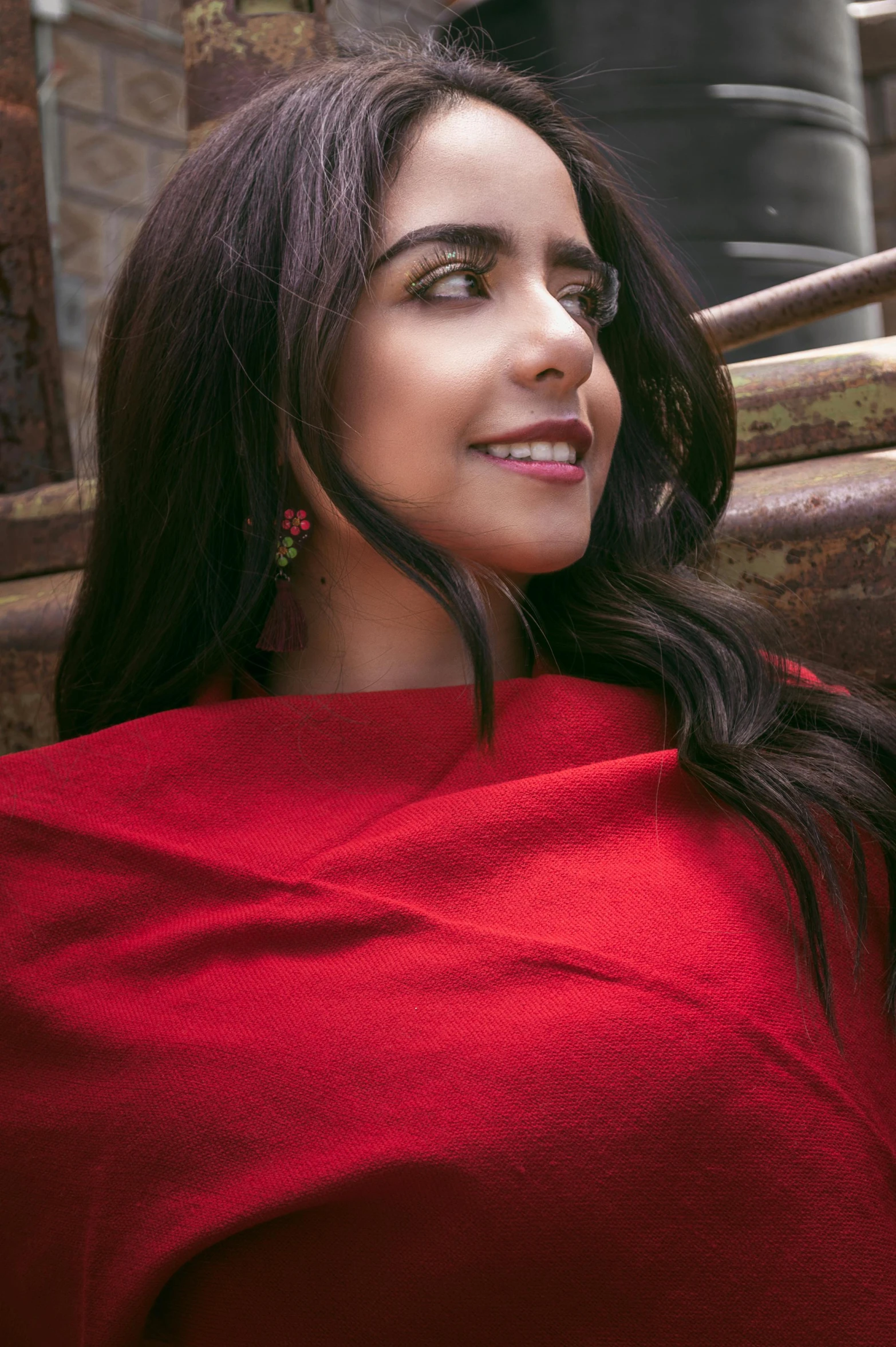 a woman in a red shawl looking off to the right