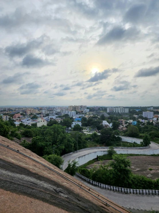 an overcast sky, a bench and buildings in the background