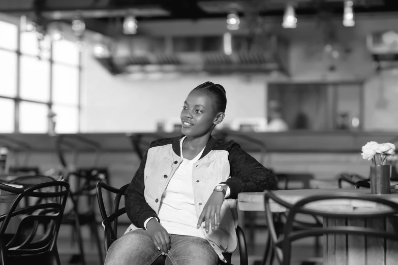 a beautiful woman sitting in a chair smiling