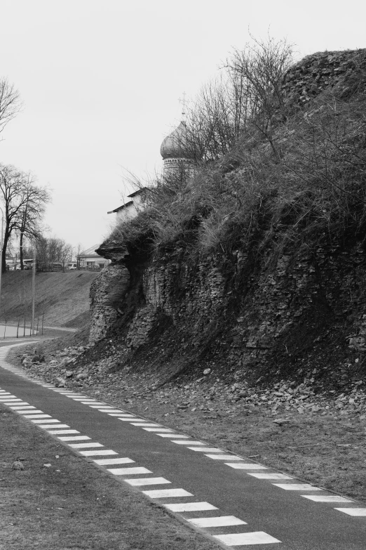 a car driving down the road next to a steep hill