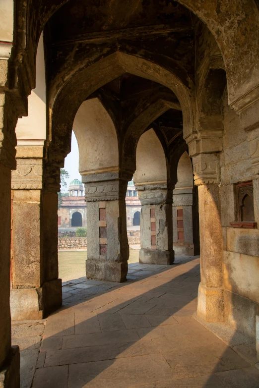 an arched corridor at the end of a brick lined building