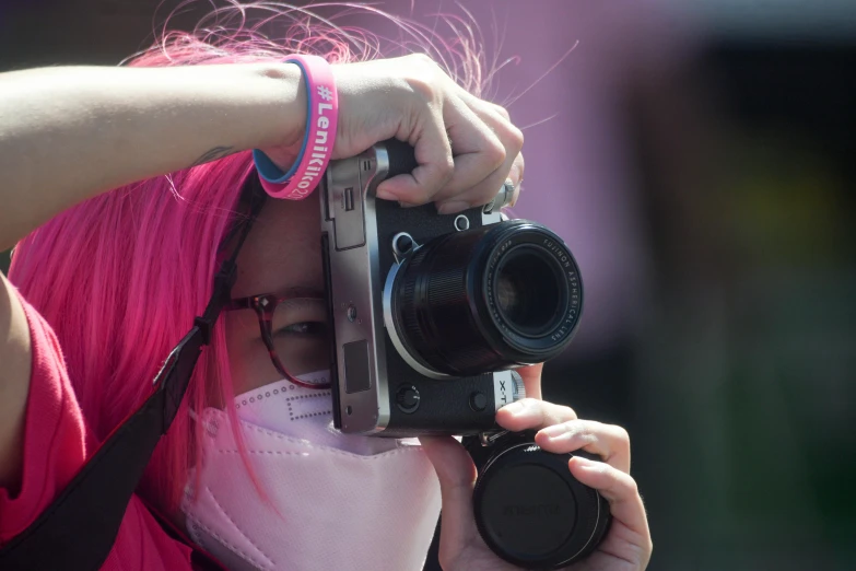a person taking pictures with a camera in front of her