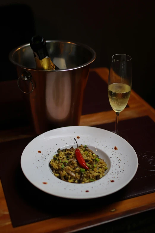 white plate filled with rice and a glass of wine