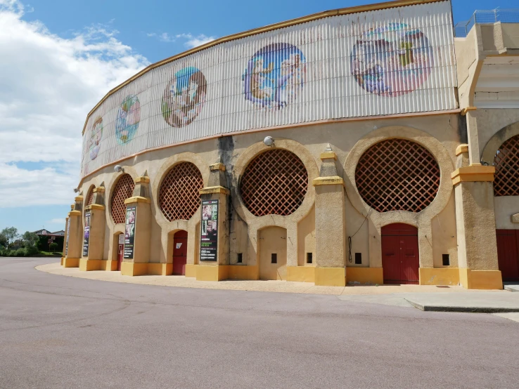 a large brick building with arched windows and a sky background