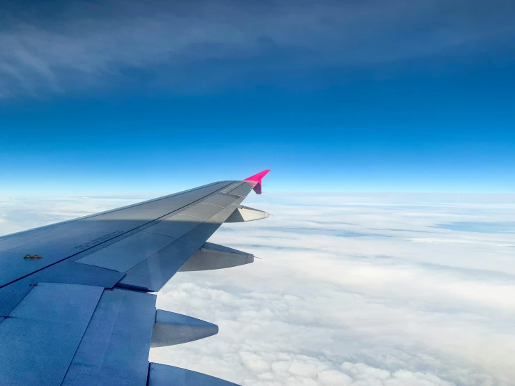 an airplane wing is shown above the clouds