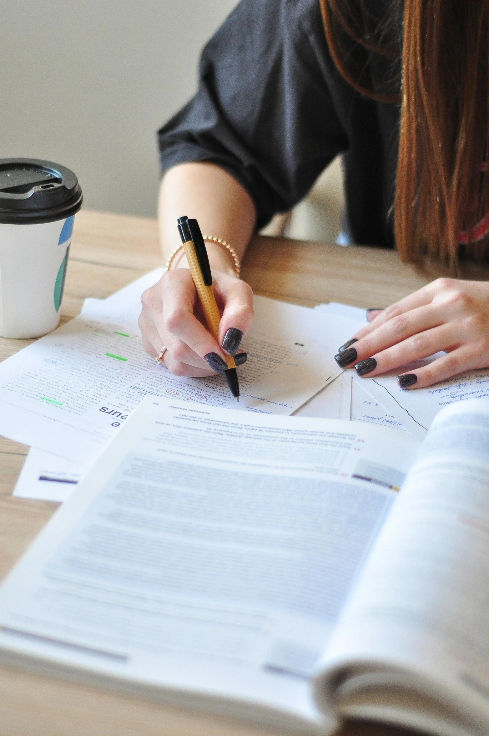 a close - up of the hands of a woman who is writing on a piece of paper