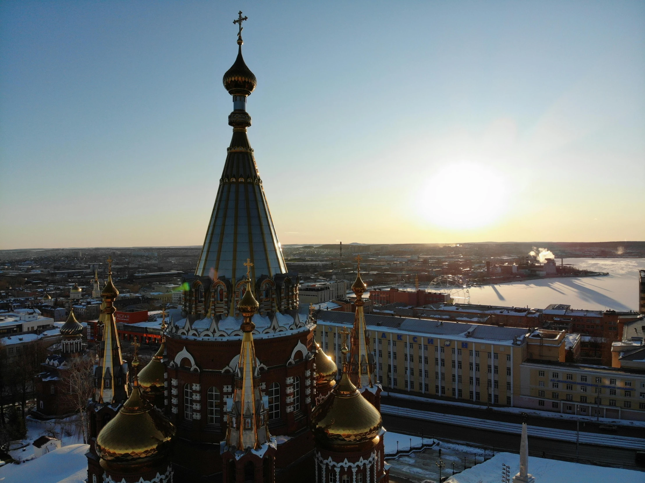 a sunset view over buildings and a snow covered ground