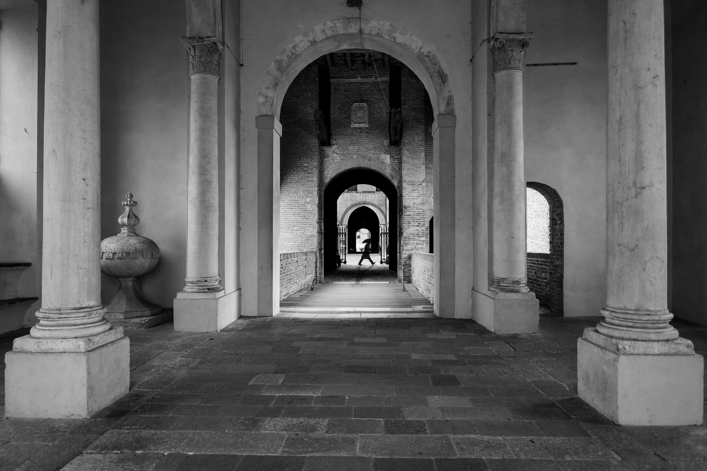 a long hallway with columns and pillars in the middle of it