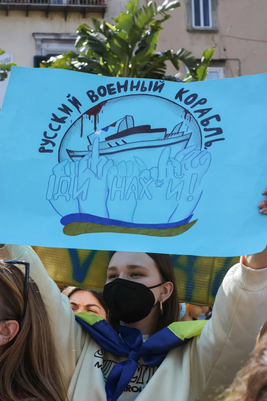 people are holding up a sign with a boat on it