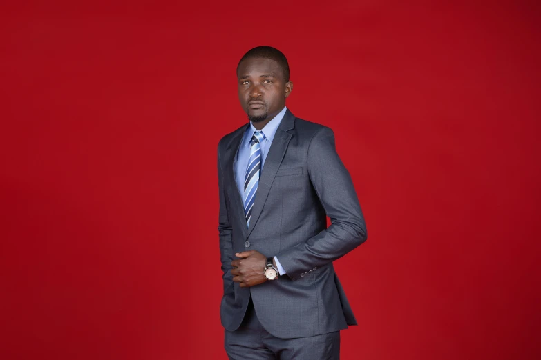 a man in a suit against a red backdrop